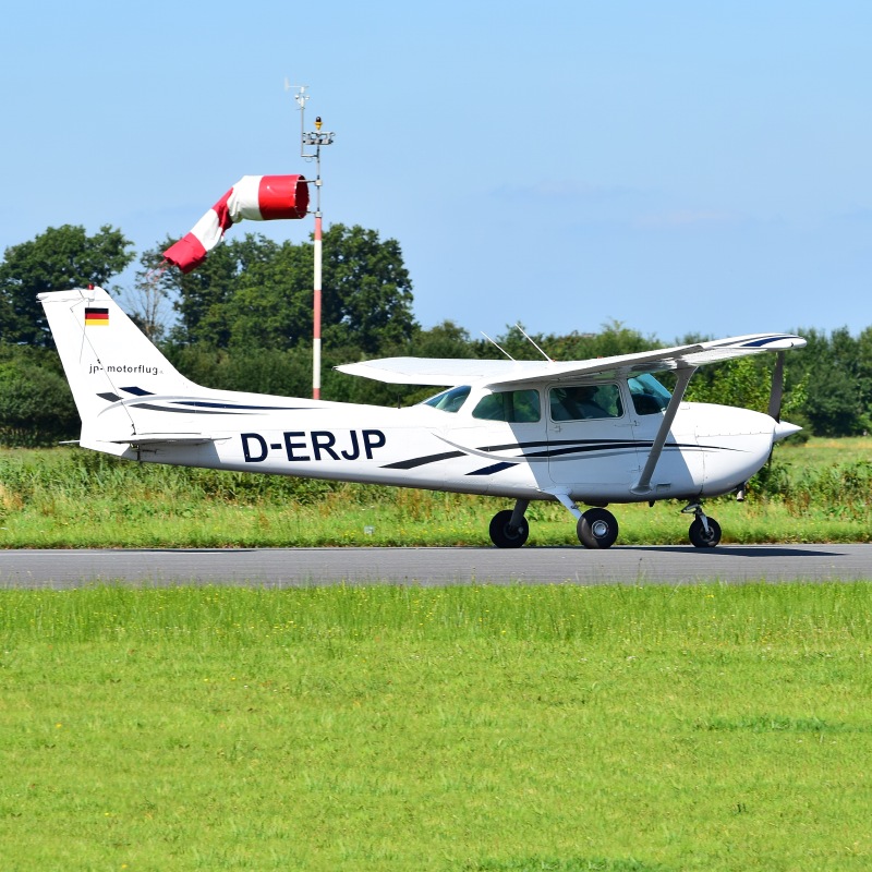 Small aircraft on runway on sunny day