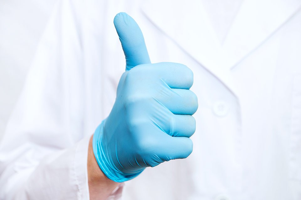 Thumbs up from a hand in a glove