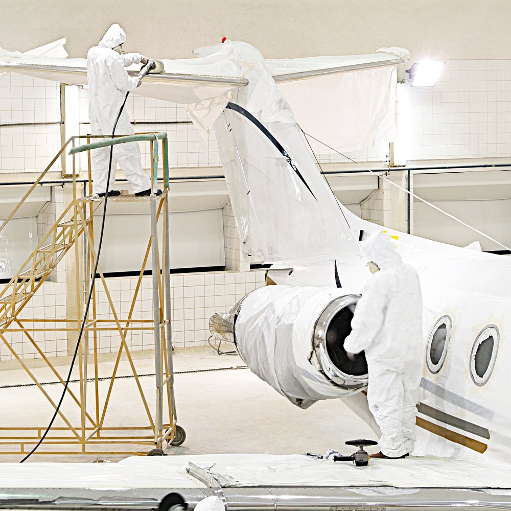 People in protective clothing working on a plane