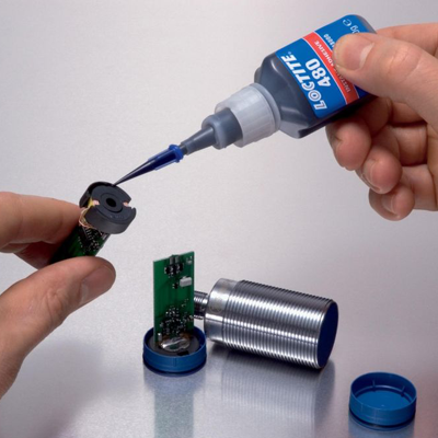 Loctite 480 bottle being applied to electrical parts