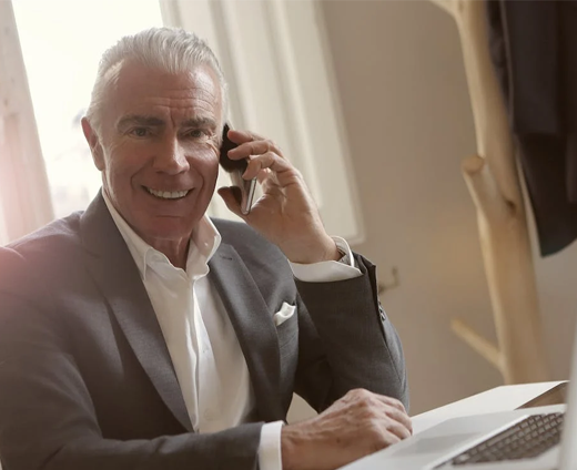 man smiling on phone at desk