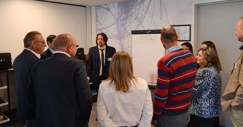 People standing in a room gathered round a flip chart