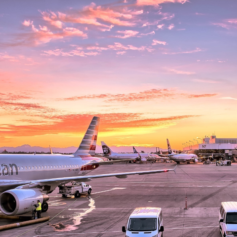 Many aircraft in airport with sunset